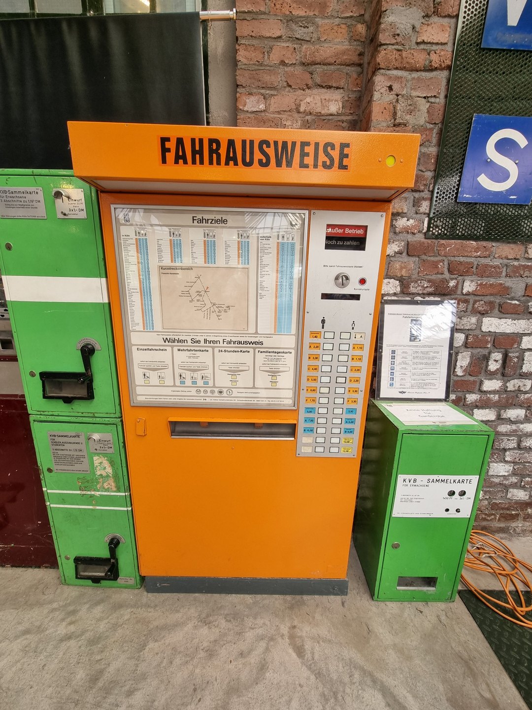 Alter orangefarbener Fahrkartenautomat und grüne Fahrscheingeräte im Straßenbahnmuseum Thielenbruch